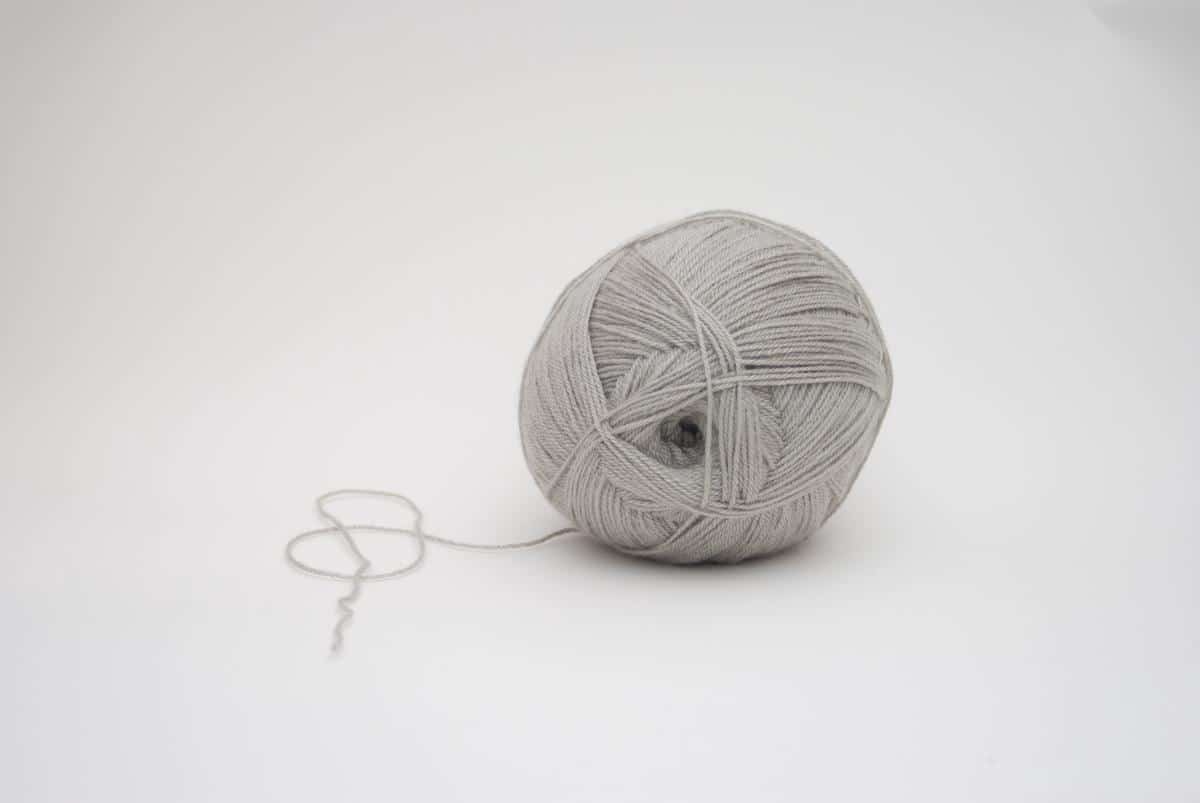 Image of a kitten playing with a ball of yarn, representing the topic of kitten training schedule.
