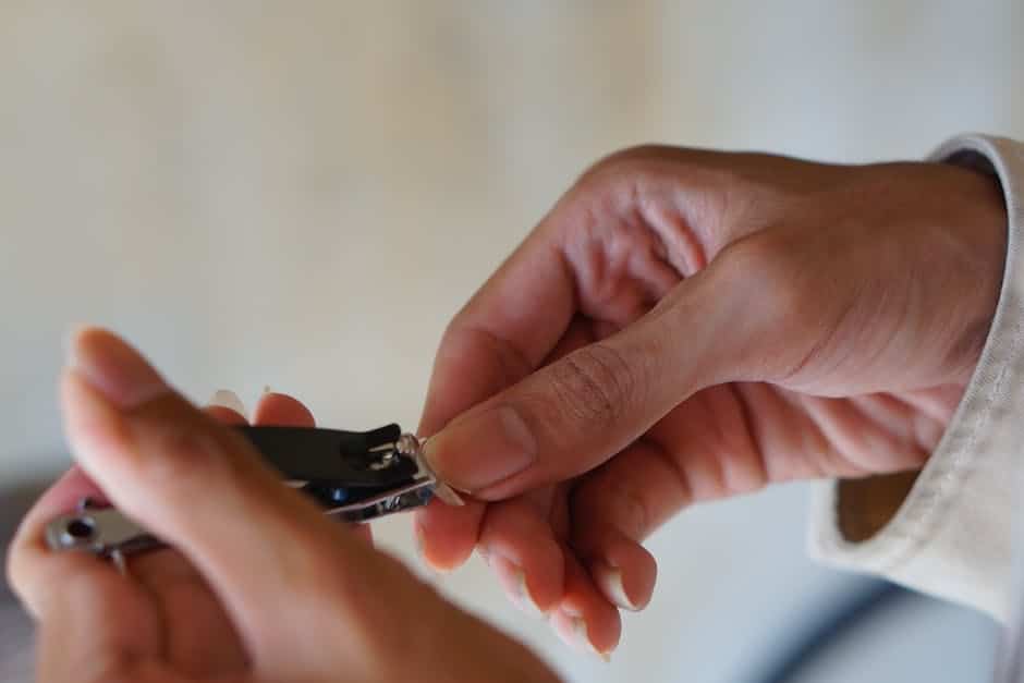 Image of various nail trimming tools such as guillotine clippers, scissor-style clippers, grinding tool, and electric clippers.